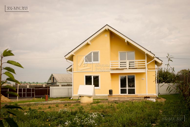 Построенный в с Озерецкое Московской области небольшой каркасный дом 151 кв м с отделкой желтой штукатуркой с балконом и открытой террасой  — 5
