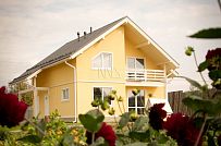 Построенный в с Озерецкое Московской области небольшой каркасный дом 151 кв м с отделкой желтой штукатуркой с балконом и открытой террасой  - мини - 7
