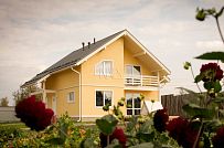 Построенный в с Озерецкое Московской области небольшой каркасный дом 151 кв м с отделкой желтой штукатуркой с балконом и открытой террасой  - мини - 1