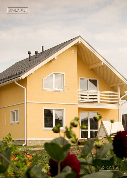 Построенный в с Озерецкое Московской области небольшой каркасный дом 151 кв м с отделкой желтой штукатуркой с балконом и открытой террасой 