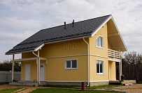 Построенный в с Озерецкое Московской области небольшой каркасный дом 151 кв м с отделкой желтой штукатуркой с балконом и открытой террасой  - мини - 5