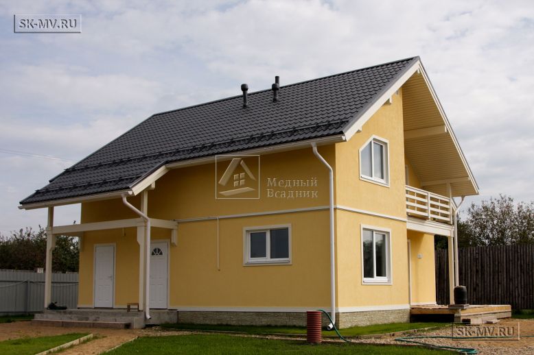 Построенный в с Озерецкое Московской области небольшой каркасный дом 151 кв м с отделкой желтой штукатуркой с балконом и открытой террасой  — 4