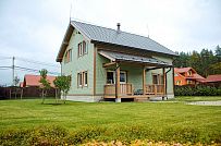 Построенный в п Борисово небольшой двухэтажный каркасный дом 147 кв.м с фасадом из светло зеленой вагонки, сауной, навесом для авто и четырьмя спальнями - мини - 1