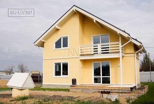 Построенный в с Озерецкое Московской области небольшой каркасный дом 151 кв м с отделкой желтой штукатуркой с балконом и открытой террасой  - 2